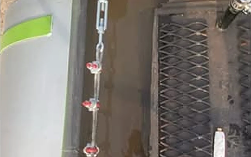 Cable de línea de vida con tensor, cadena y abrazaderas sobre un carrotanque